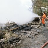 Des pompiers éteignent le feu dans un des chalets de l'OTS à Salvan, le mercredi 5 octobre 1994.